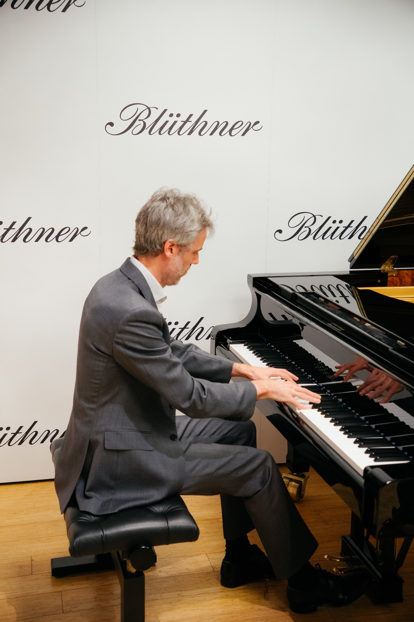 Pianist performing at a Blüthner grand piano